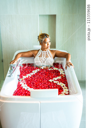 Asian girl in a bathtub with flowers in a shape of a heart in Patong, in Phuket, Thailand 115359686