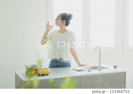 キッチンで水を飲む女性　 115360752