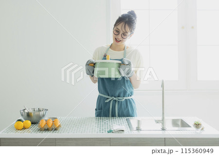 キッチンに立つ若い女性 115360949