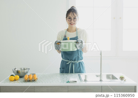 キッチンに立つ若い女性 115360950