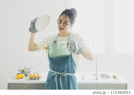 キッチンに立つ若い女性 115360953