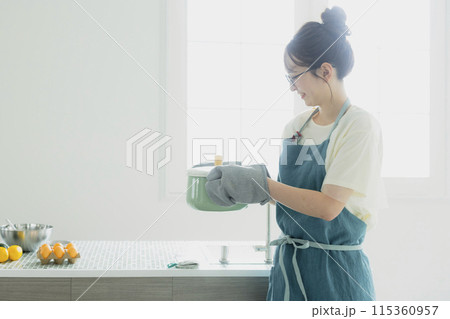 キッチンに立つ若い女性 115360957