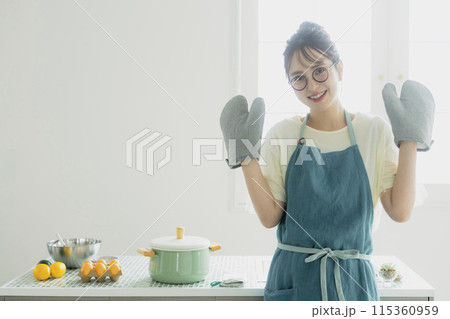 キッチンに立つ若い女性 115360959