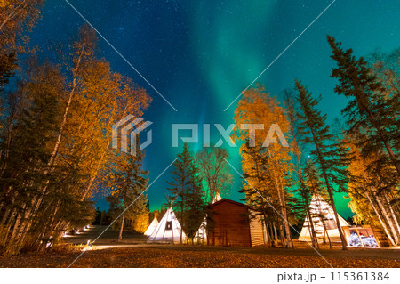 Amazing northern lights dancing over the light up Tipi or Tepees at Aurora Village in Yellowknife, Northwest Territories, Canada. Amazing northern lights dancing over the light up Tipi or Tepees at Aurora Village in Yellowknife, Northwest Territories, Canada. 115361384