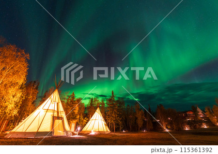 Amazing northern lights dancing over the light up Tipi or Tepees at Aurora Village in Yellowknife, Northwest Territories, Canada. 115361392