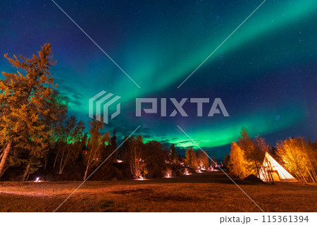 Amazing northern lights dancing over the light up Tipi or Tepees at Aurora Village in Yellowknife, Northwest Territories, Canada. 115361394
