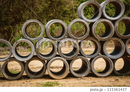 A stack of concrete ring pipes piled and creating a symmetrical arrangement 115361437