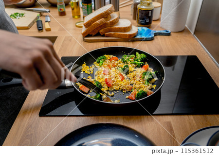 Chef at the kitchen preparing tofu scramble with vegetables 115361512