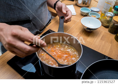 Chef at the kitchen preparing lentils soup with cauliflower and broccoli Chef at the kitchen preparing lentils soup with cauliflower and broccoli 115361527