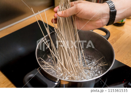 Chef at the kitchen preparing japanese buckwheat pasta with lentils 115361535