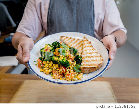 Chef at the kitchen preparing tofu scramble with vegetables 115361558