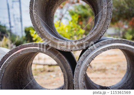 A stack of concrete ring pipes piled and creating a symmetrical arrangement 115361569