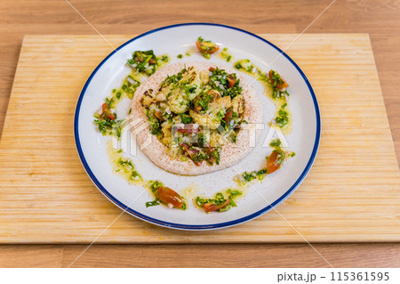 Tasty bean porridge with cauliflower and vegetables on white plate 115361595