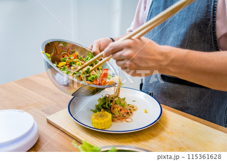 Chef at the kitchen preparing spicy glass noodle salad 115361628