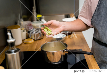 Chef at the kitchen preparing green curry with herbs and rice 115361658