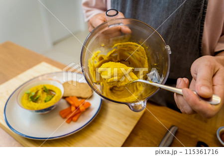Chef at the kitchen preparing chickpea porridge with ginger Chef at the kitchen preparing chickpea porridge with ginger 115361716