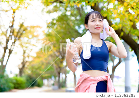 秋の街路樹の道をジョギングする若い女性 ダイエット ボディメイク タオルで汗をふく 秋の街路樹の道をジョギングする若い女性 ダイエット ボディメイク タオルで汗をふく 115362285