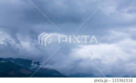 雨の日の山頂を、覆いかぶさりながら流れていく雨雲 雨の日の山頂を、覆いかぶさりながら流れていく雨雲 115362318