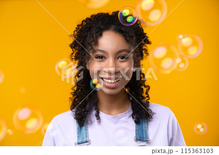 Happy emotions concept. Positive and beautiful young woman laughs poisitively looks aside with carefree face expression wears casual isolated over yellow studio background. 115363103