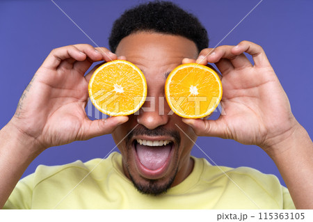 Emotional young black guy in casual raising fists up studio background, celebrating success, happy handsome african american millennial man sharing good emotions. 115363105