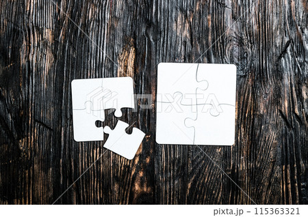 white puzzles on dark wooden table white puzzles on dark wooden table 115363321