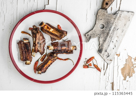 Pork ribs on white plate, top view. 115363445