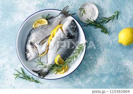 Fresh raw dorado fish cooking with lemon and rosemary. Sea bream, dorado. Seafood, healthy food. Top view 115363804