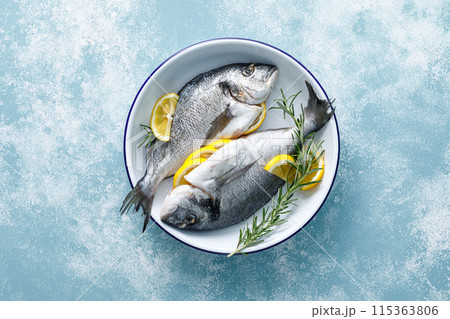 Fresh raw dorado fish cooking with lemon and rosemary. Sea bream, dorado. Seafood, healthy food. Top view Fresh raw dorado fish cooking with lemon and rosemary. Sea bream, dorado. Seafood, healthy food. Top view 115363806
