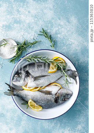 Fresh raw dorado fish cooking with lemon and rosemary. Sea bream, dorado. Seafood, healthy food. Top view Fresh raw dorado fish cooking with lemon and rosemary. Sea bream, dorado. Seafood, healthy food. Top view 115363810