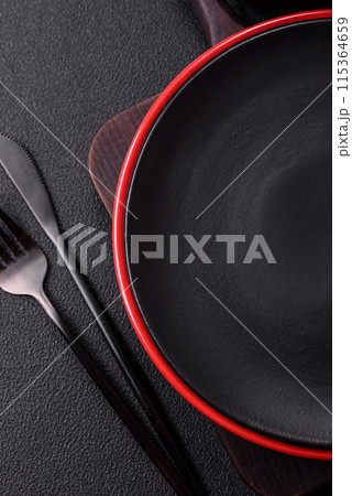 Empty ceramic round plate on dark textured concrete background Empty ceramic round plate on dark textured concrete background 115364659