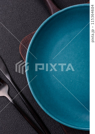 Empty ceramic round plate on dark textured concrete background 115364684
