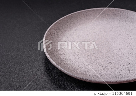 Empty ceramic round plate on dark textured concrete background 115364691