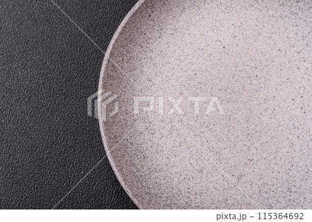 Empty ceramic round plate on dark textured concrete background 115364692