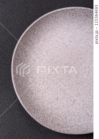 Empty ceramic round plate on dark textured concrete background 115364693