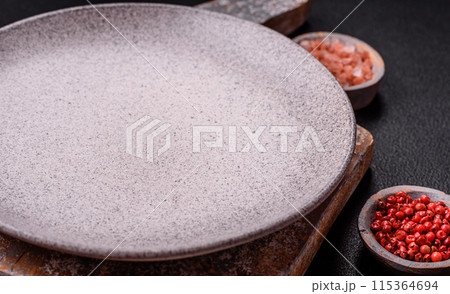 Empty ceramic round plate on dark textured concrete background Empty ceramic round plate on dark textured concrete background 115364694