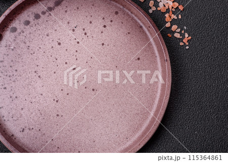 Empty ceramic round plate on dark textured concrete background 115364861