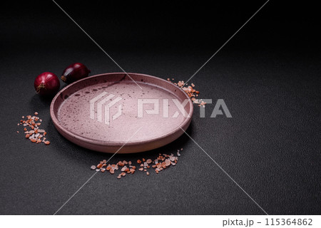 Empty ceramic round plate on dark textured concrete background 115364862