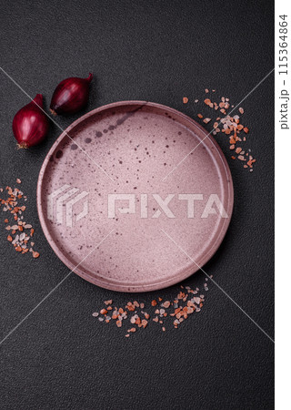 Empty ceramic round plate on dark textured concrete background Empty ceramic round plate on dark textured concrete background 115364864