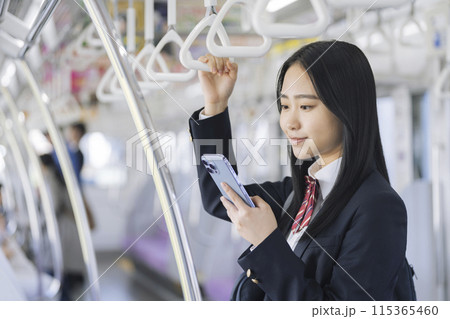 電車の中でスマホを見る女子高校生 電車の中でスマホを見る女子高校生 115365460