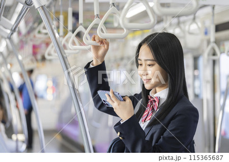 電車の中でスマホを見る女子高校生 115365687