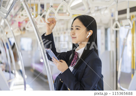 スマートフォンを持ってイヤホンをつけた女子高校生　電車通学　イメージ 115365688