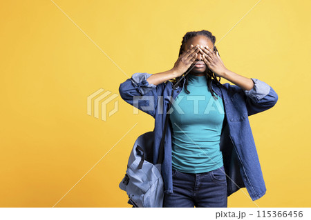 Tired BIPOC woman covering face with palms, exhausted after long day at work. African american person in need of break from job, obstructing eyes with hand, isolated over studio background 115366456