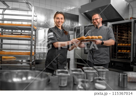 Man and woman preparing French baguettes in kitchen Man and woman preparing French baguettes in kitchen 115367014