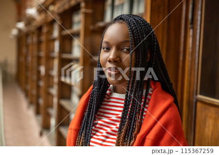 Portrait of a long-haired african american young woman in the library 115367259