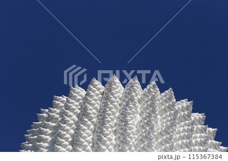 The top head part of big white Buddha statue in a blue sky background. The top head part of big white Buddha statue in a blue sky background. 115367384