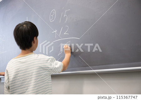算数の授業で黒板にチョークで書く小学生 算数の授業で黒板にチョークで書く小学生 115367747