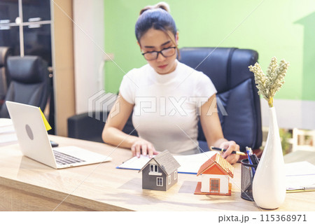 Businesswoman selling house real estate agent at office desk. Women working home insurance mortgage sale apartment. Asian women dealership real estate rental home. Businessperson agency sign contract Businesswoman selling house real estate agent at office desk. Women working home insurance mortgage sale apartment. Asian women dealership real estate rental home. Businessperson agency sign contract 115368971