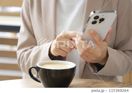 カフェでスマートフォンを使うビジネスウーマン 顔無し カフェでスマートフォンを使うビジネスウーマン 顔無し 115369264