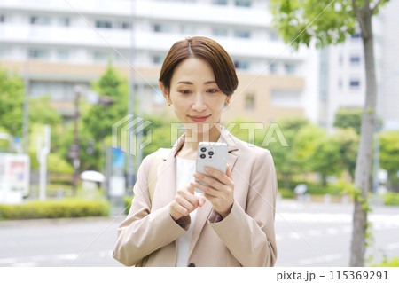 外でスマートフォンを使うビジネスウーマン 115369291