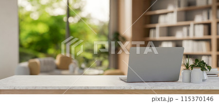 A laptop computer on a table in a modern, spacious living room or private CEO office. 115370146